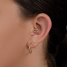 a close up of a woman's ear with two small hoops on it