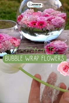 a person holding a flower in front of a bowl filled with water and pink flowers