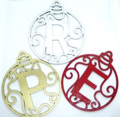 three metal ornaments with the letter r on them, one in gold and one in red