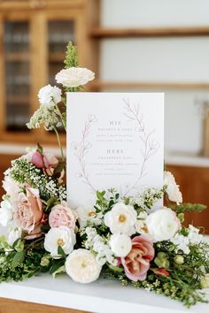 a table topped with flowers and a card