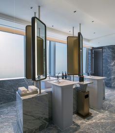 a bathroom with two sinks, mirrors and large windows overlooking the ocean in front of it