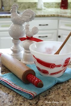 a bowl and rolling pin sitting on a kitchen counter next to an egg beater