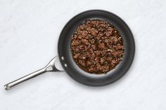 a frying pan filled with food on top of a white counter