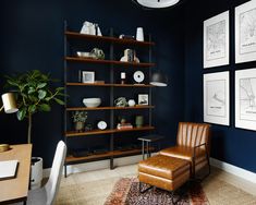 an office with blue walls and leather chair in front of a bookcase filled with books