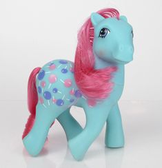 a toy pony with pink hair and blue polka dots on it's body, standing upright