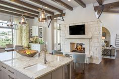 a large kitchen with an island and fireplace