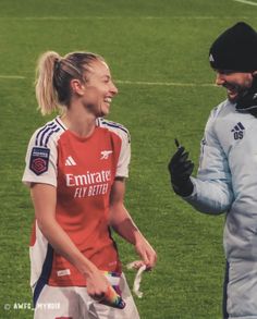 two soccer players are talking on the field