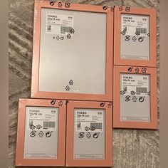 four pink frames sitting on top of a bed next to each other with the same sticker