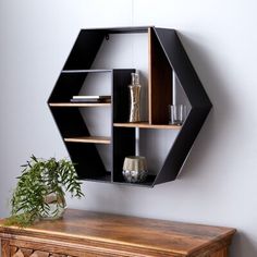 a wooden table topped with a shelf next to a potted plant