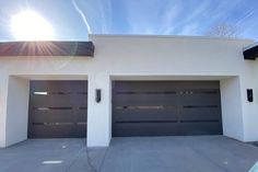 a white house with two black garage doors