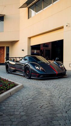 a black sports car parked in front of a building