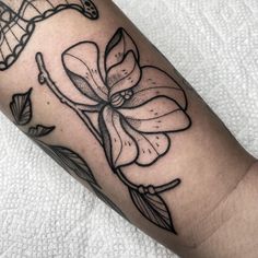 a black and white flower tattoo on the arm