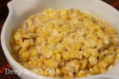 a white bowl filled with corn on top of a table