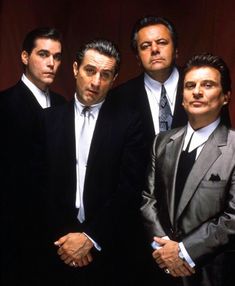 four men in suits and ties posing for a photo