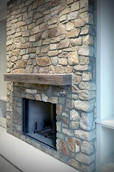 a stone fireplace with a wooden mantle