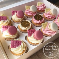 a box filled with lots of cupcakes covered in pink and white frosting