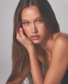 a beautiful young woman with long hair posing for the camera