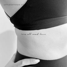 a woman's stomach with the words, we are all mad here written on it