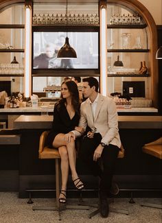 a man and woman sitting at a bar