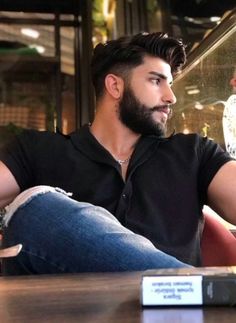 a man with a beard sitting at a table