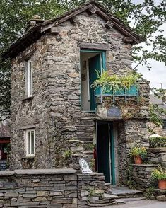 an old stone building with plants growing out of it