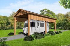 an rv is parked in the grass under a covered area with shrubs and trees around it