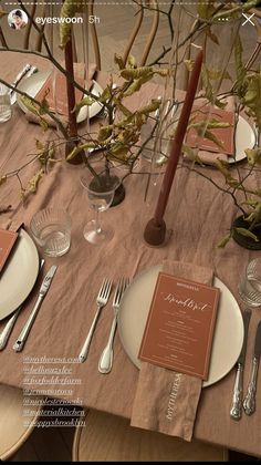 the table is set with silverware and place settings