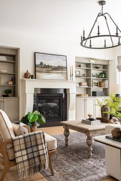 a living room filled with furniture and a fire place in front of a white fireplace