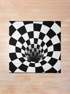 a black and white checkered rug with a hole in the center on a wooden floor