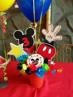 a mickey mouse centerpiece with balloons and streamers