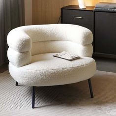 a white chair sitting on top of a rug next to a window