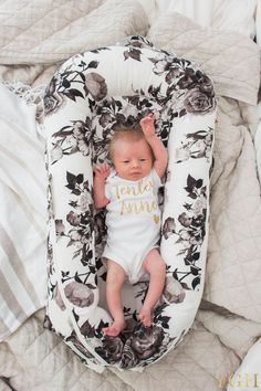 a baby laying in an inflatable mattress on top of a bed next to pillows