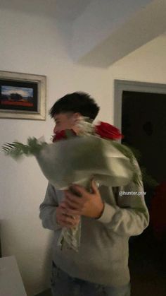 a man holding a bouquet of flowers in his hands