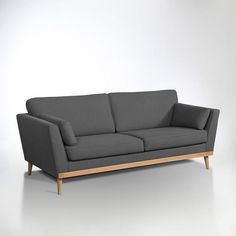 a gray couch sitting on top of a white floor next to a wooden frame chair