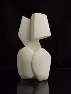 a white sculpture sitting on top of a black table