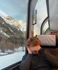 a young man sitting in the back of a bus