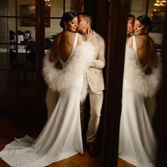 the bride and groom are posing for a photo in front of a mirror with their arms around each other