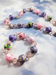 "The \"Raining Gumballs\" beaded jewelry set features an adorable kids' beaded necklace and bracelet set.  The pieces are made with various 13mm floral and marble patterned clay rounds and 5 mm pink crystal rondelle spacer beads.  The necklace is 15-inches long and includes a white gold plated magnetic clasp.  The bracelet is 5.75 inches long and made with stretch elastic.  This set would make a wonderful gift for girls!  Perfect for the little fashionista in your life :) Note that each piece ca Crystal Beads Necklace, Gifts For Children, Kids Jewelry, Beads Necklace, Pink Crystal, Necklace Bracelet, Spacer Beads, Gifts For Girls, Pandora Charm Bracelet