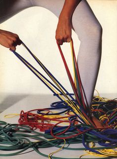 an image of a person bending over with many wires on the floor in front of them