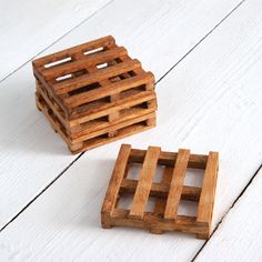 two wooden crates sitting on top of a white wood floor next to each other,