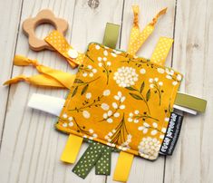 a yellow and white flowered cloth with two wooden pegs on top of it