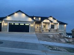 a large house with two garages and lights on