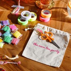 a pair of scissors sitting on top of a table next to spools of thread