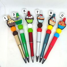 six pens with different designs and numbers on them