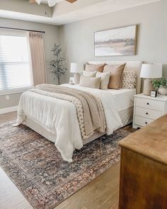 a bedroom with a bed, dressers and window in it's center area