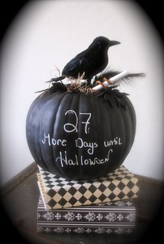 a black bird sitting on top of a halloween pumpkin with writing on the side and words written on it