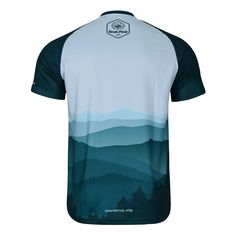 the back of a men's cycling jersey with mountains in the distance and blue sky