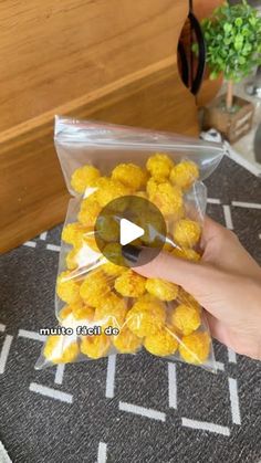 a person holding a bag full of yellow candies on top of a carpeted floor