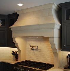 a stove top oven sitting inside of a kitchen next to black cabinets and counter tops