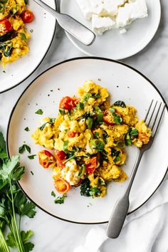 two plates with eggs and vegetables on them